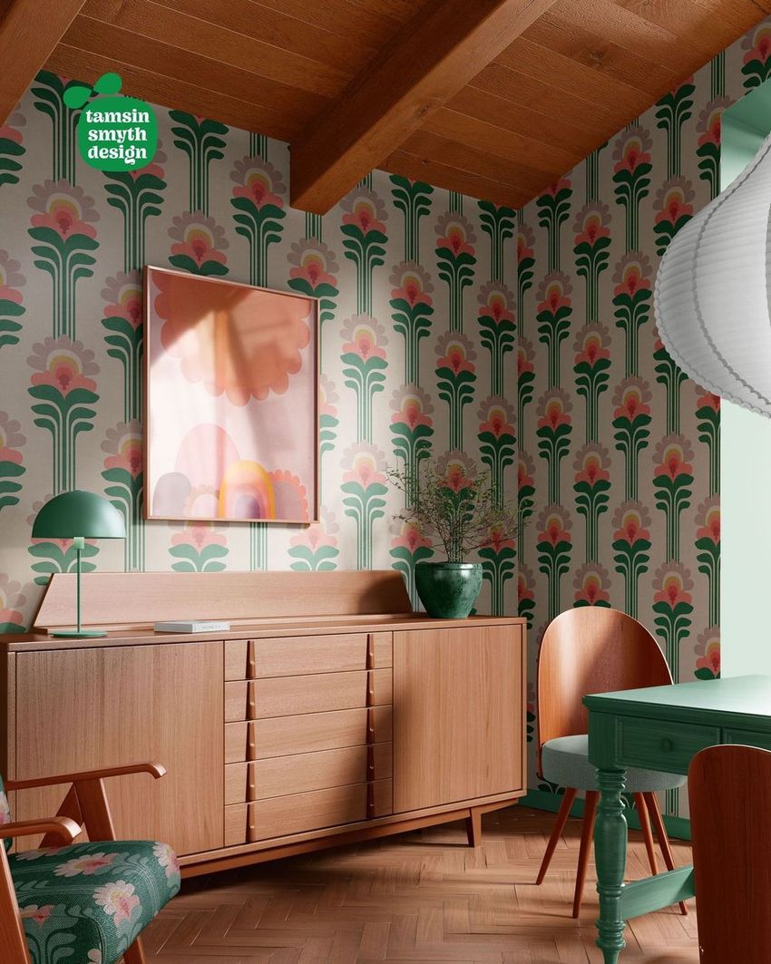 Retro dining corner wallpaper mockup featuring bold green and pink floral patterns, wood furniture, and framed abstract art.
