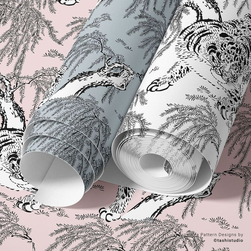 Paper wallpaper mockup featuring two rolled sheets with intricate tiger and foliage patterns on a pink and gray background.