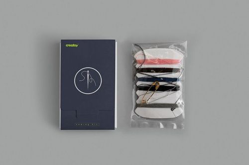 Sewing kit mockup showing a closed navy blue box with needle and thread icon next to a clear pouch of assorted threads.