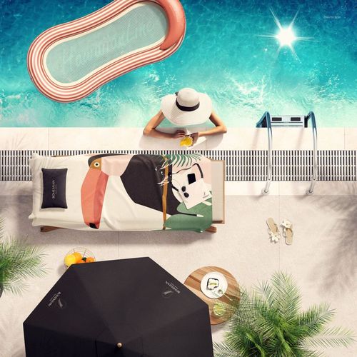 Overhead perspective of a mockup towel with artistic patterns on a lounge chair by a bright blue swimming pool.