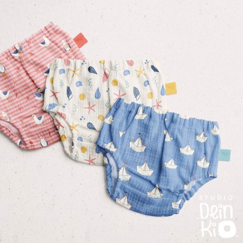 Set of three baby muslin pants mockup with colorful sea-themed patterns, displayed flat on a neutral background.