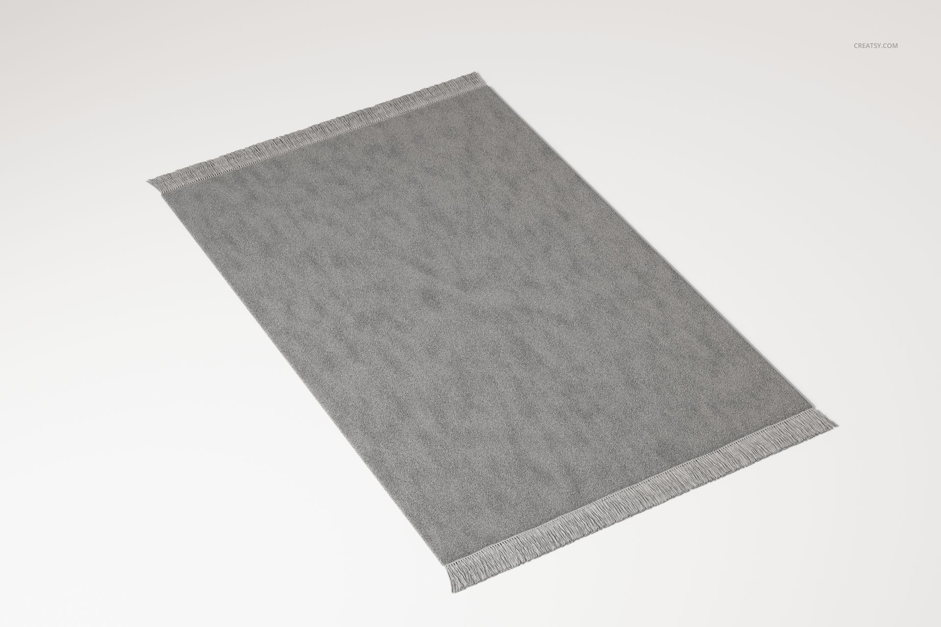 Small rectangular fringed rug in solid gray color, viewed from a slight angle on a plain white background.