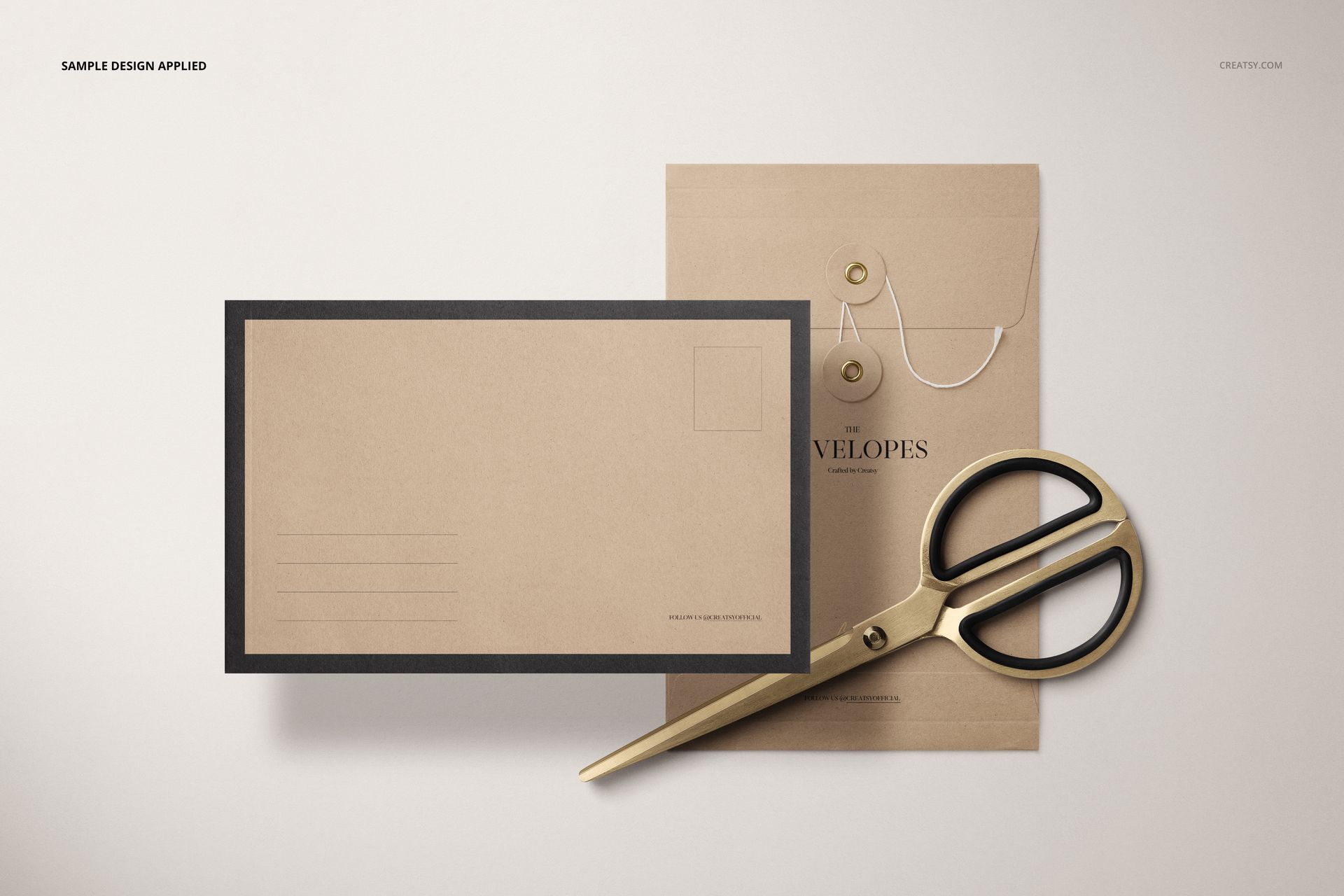 Stationery mockup set showing two kraft envelopes with string closures and a pair of gold scissors on a neutral background.
