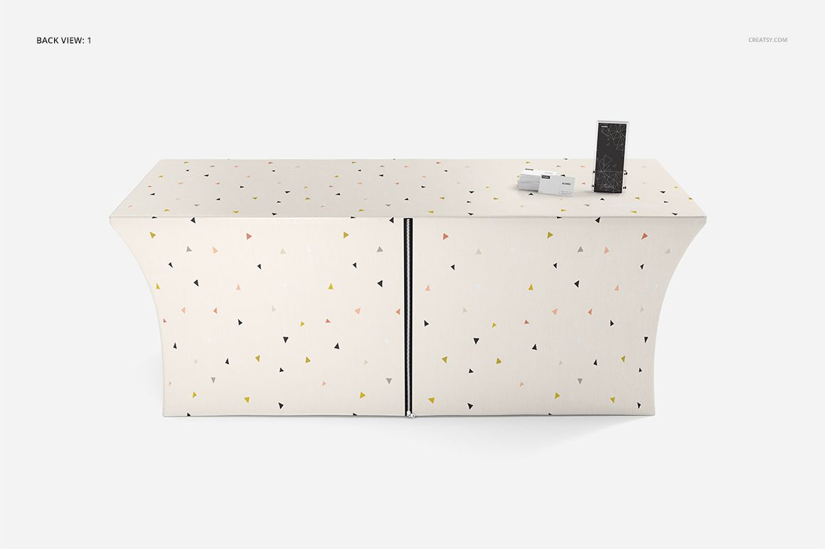 Back view of a fitted tablecloth mockup featuring scattered triangle shapes in pastel colors, with props on top.