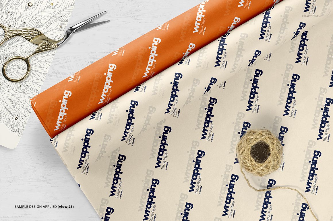 Two sheets of wrapping tissue paper mockup, one orange and one white, displayed from a top view with scissors and twine.