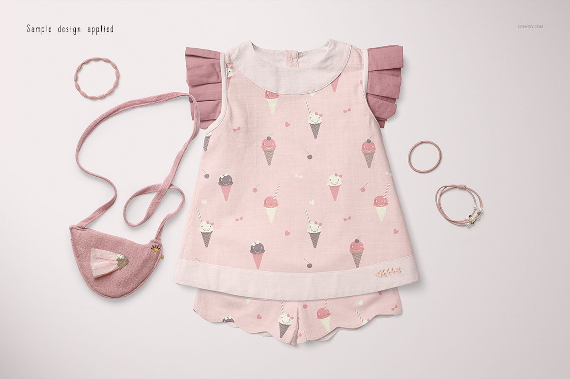 PSD mockup showing a baby blouse and shorts in pastel pink, decorated with playful ice cream prints and pink props.