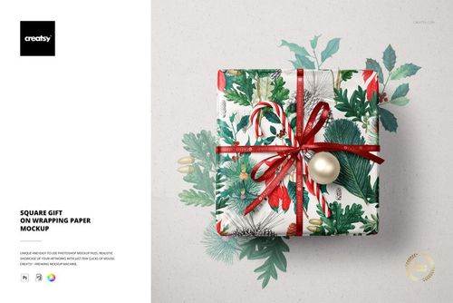 Square Christmas gift mockup with festive wrapping paper, red ribbon, candy cane, and bauble, top view.