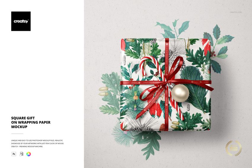 Square Christmas gift mockup with festive wrapping paper, red ribbon, candy cane, and bauble, top view.