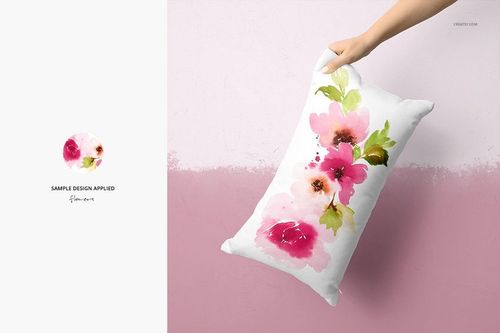 Hand holding a rectangular pillow mockup with pink and green watercolor flowers on a white fabric background.