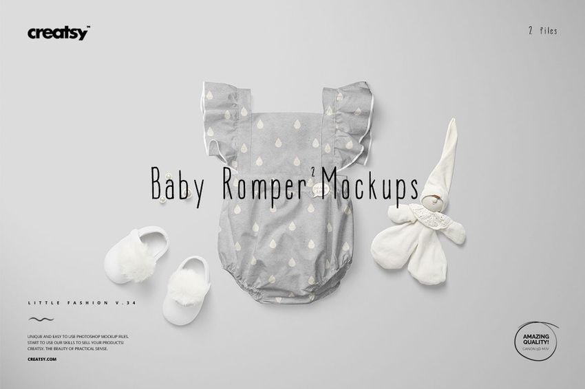 Front view of a baby romper mockup with ruffled sleeves, light gray color and white heart pattern, displayed with baby shoes and a soft toy on a light background.