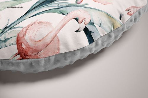 Detailed section of a nursing pillow mockup showing pink flamingos and green leaves on a light fabric cover.
