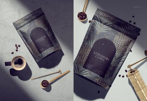 Coffee packaging mockup with dark blue and gold leaf pattern, shown from top and angled views with coffee props.