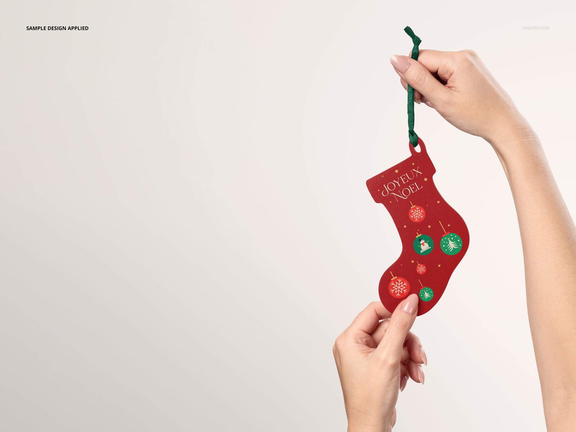 Christmas stocking ornament mockup featuring a red wooden decoration with holiday motifs, shown in hand.