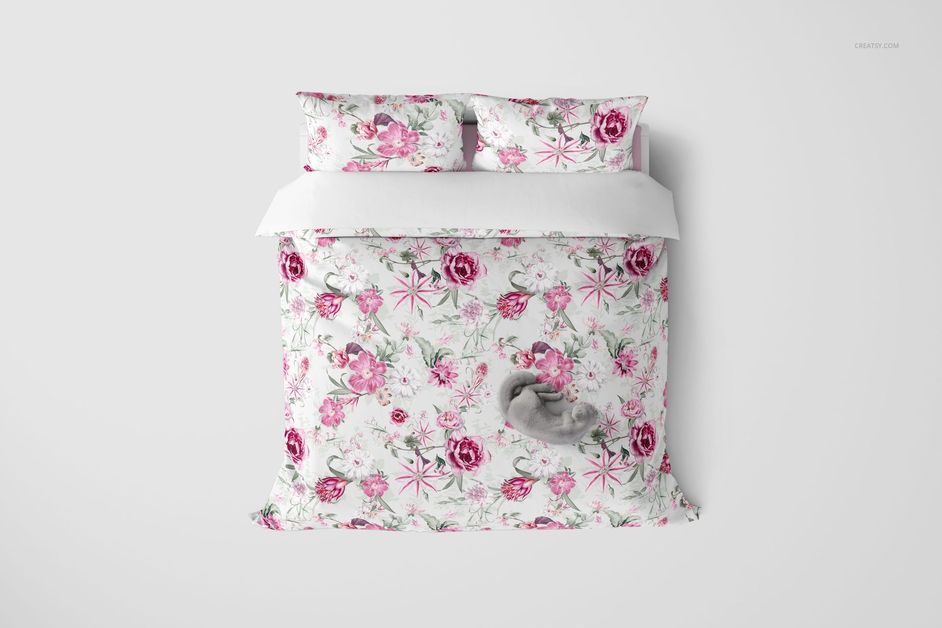 Top view of a bedding mockup set with a duvet and two pillows featuring a pink floral pattern on white.