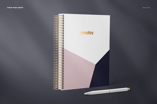 Coil binding planner mockup featuring a geometric cover in white, blush pink, and dark blue, shown with a pen.