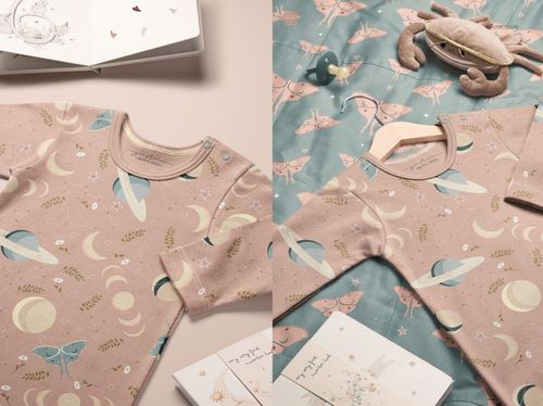 PSD mockup of a baby gown featuring pastel moons, planets, and leaves, displayed with matching fabric and accessories.