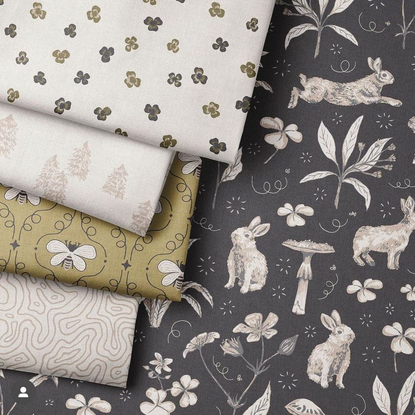 Folded fabrics mockup featuring five stacked fabric pieces with various nature-inspired patterns in neutral and earthy tones.