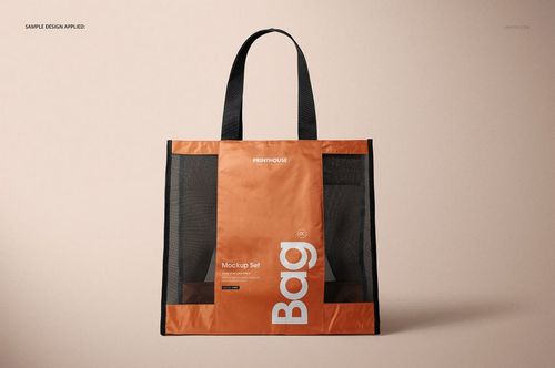 Front view of a mesh shopping tote bag mockup featuring black mesh sides and an orange center panel on a beige surface.