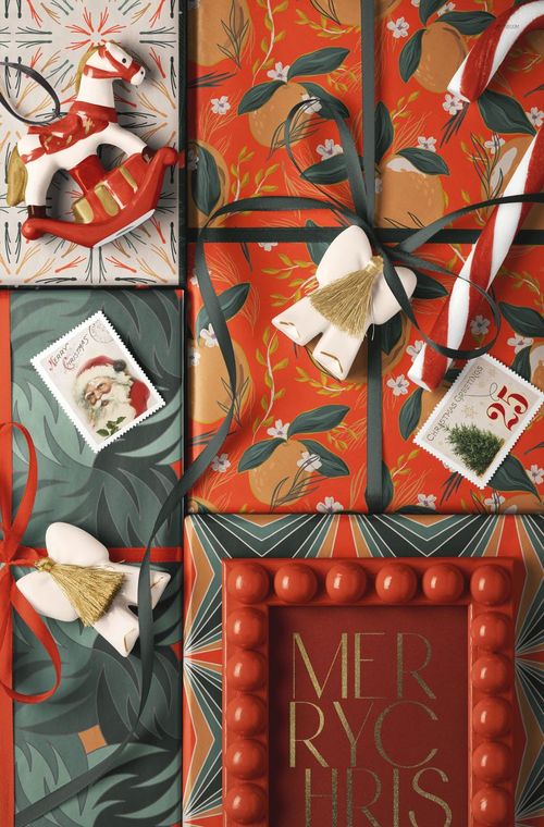 Christmas wrapped gift boxes with colorful ribbons and festive patterns, viewed from above with holiday props.