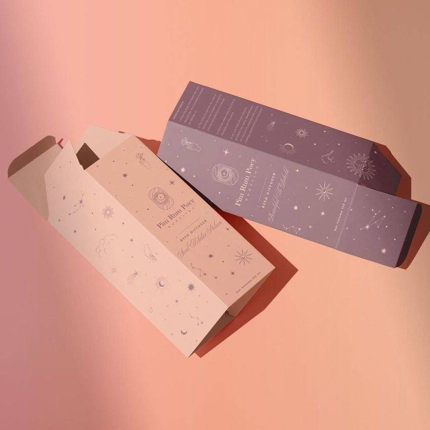 Tall box mockup featuring two rectangular packaging boxes with pastel pink and lavender colors, decorated with celestial line art.