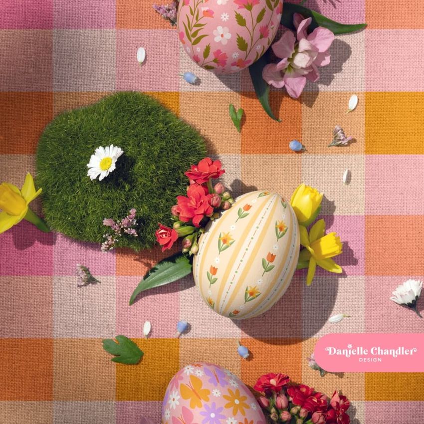 Spring-themed mockup showing patterned eggs, fresh flowers, and moss on a textured checkered surface.