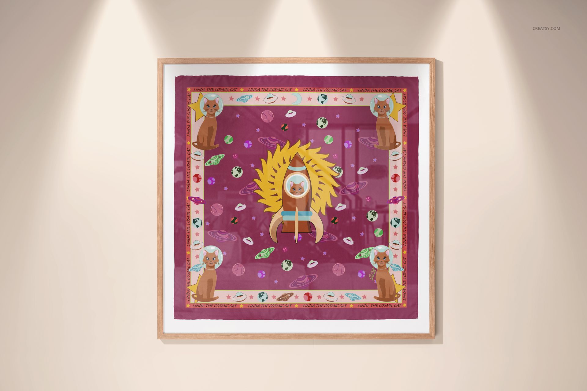 Framed silk scarf mockup featuring a vibrant design with animal motifs and decorative border, illuminated by spotlights.