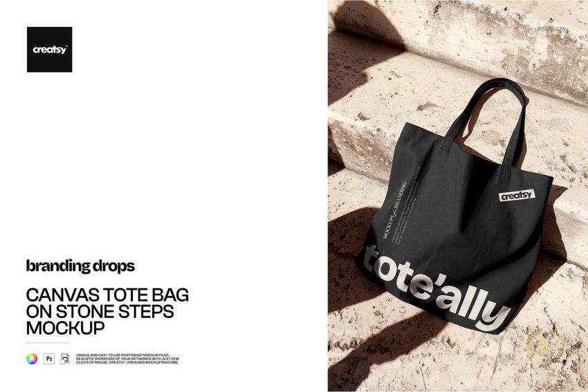 Canvas tote bag mockup featuring a black bag with white lettering, displayed on textured stone stairs in sunlight.
