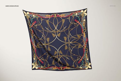 Mockup of a square silk scarf featuring an intricate gold and red design on a dark blue fabric, displayed flat.