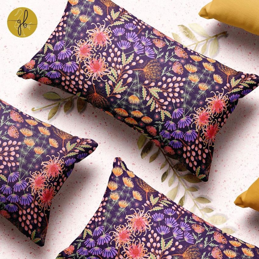 Rectangular pillow mockup featuring a vibrant floral pattern in pink, orange, and green on a dark background, viewed from above.