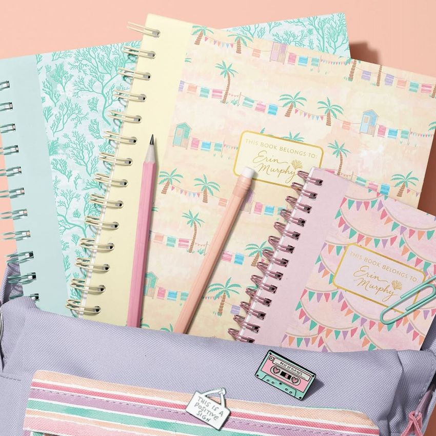 School backpack mockup with pastel spiral notebooks, pencils, and a cassette patch, arranged on a peach background.