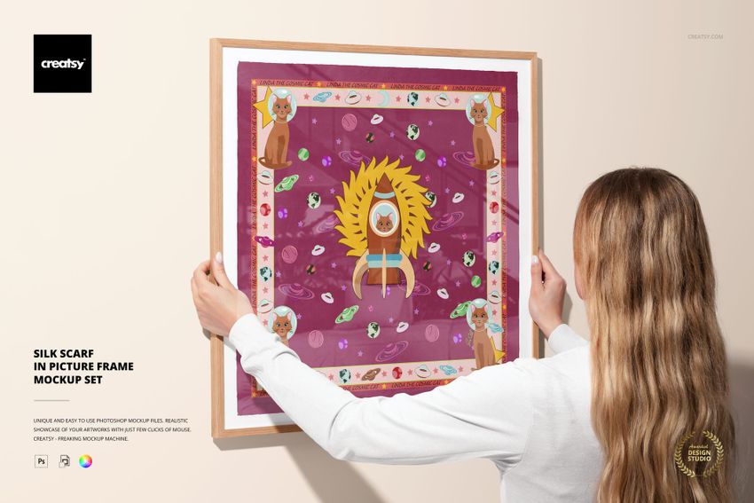 Framed silk scarf mockup featuring vibrant artwork with animal and floral motifs, held against a neutral wall.