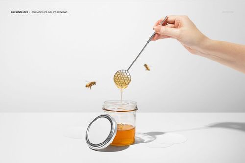 Honey jar mockup scene with transparent jar, loose lid, honey dipper dripping, bees and round stickers on table.