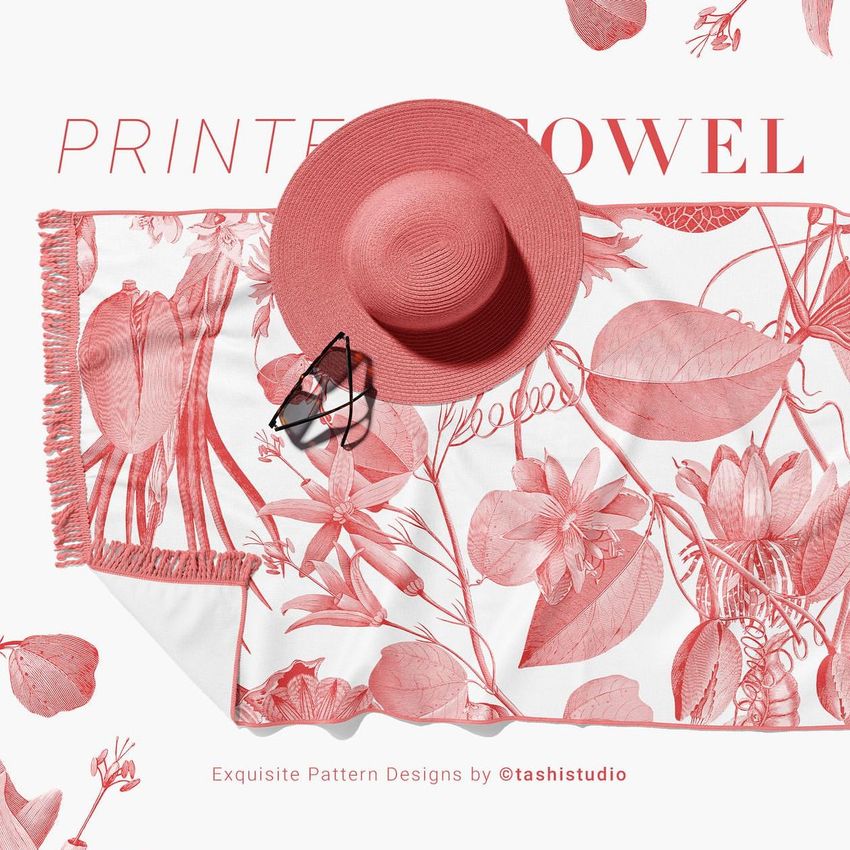 Fringed beach towel mockup with a pink floral pattern, large sunhat, and sunglasses arranged on a white background.