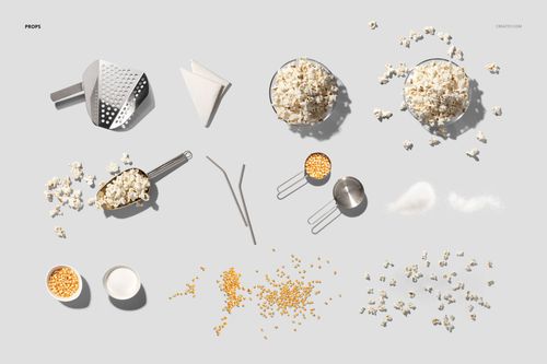 Assorted popcorn-related props on a light background, including scoops, bowls of popcorn, kernels, and measuring cups.