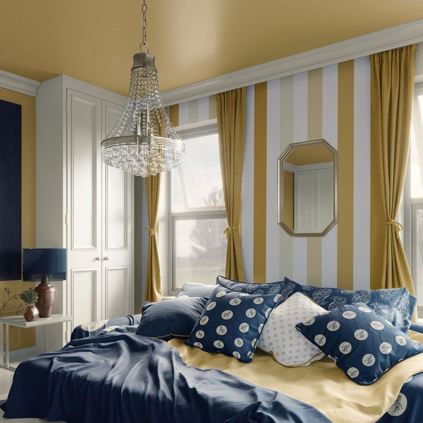 Luxury interior bedroom mockup featuring a bed with blue and yellow bedding, striped wallpaper, and a crystal chandelier.