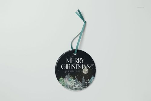 PSD mockup of a circular ceramic ornament featuring a snowy forest and 'Merry Christmas' text, top view.