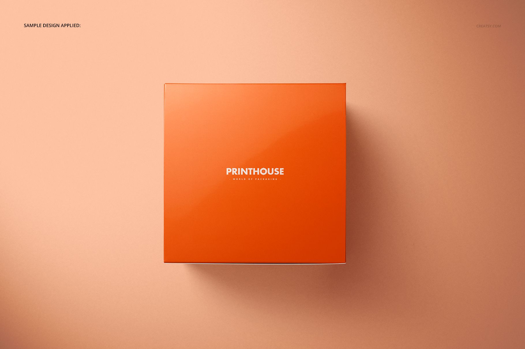 Square chipboard gloss gift box in orange color, viewed from above on a peach background, mockup scene.