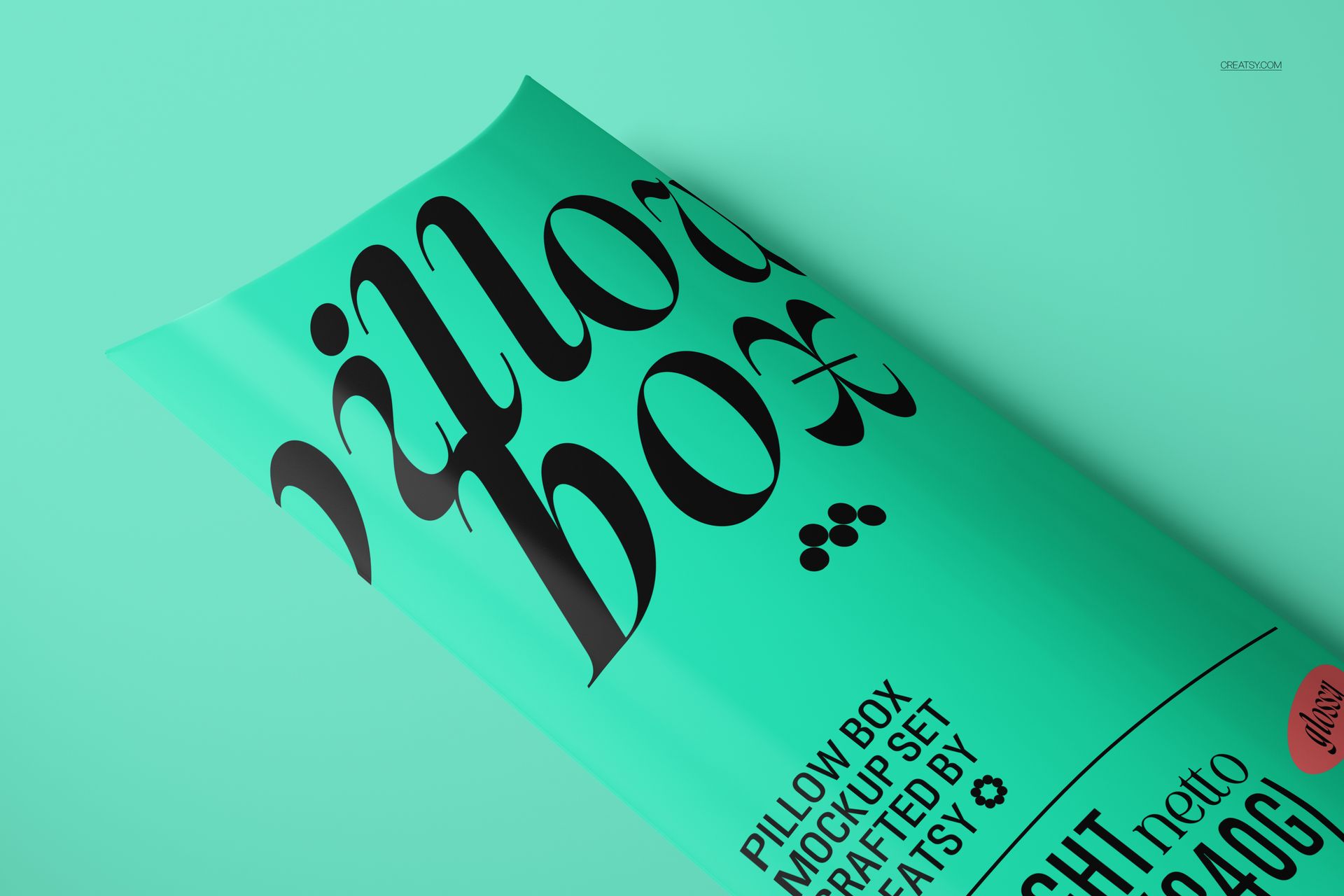 Turquoise pillow box mockup featuring large black lettering, displayed from a diagonal perspective on a plain surface.