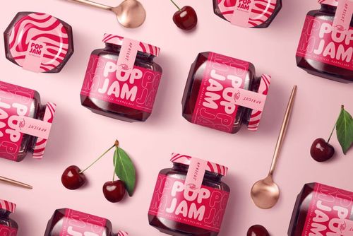 Front view of jam jar mockups with vibrant pink packaging, gold spoons, and fresh cherries on a pastel background.