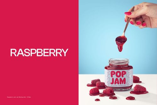 Front view of a raspberry jam jar mockup with a spoon held above, surrounded by fresh raspberries on a blue background.