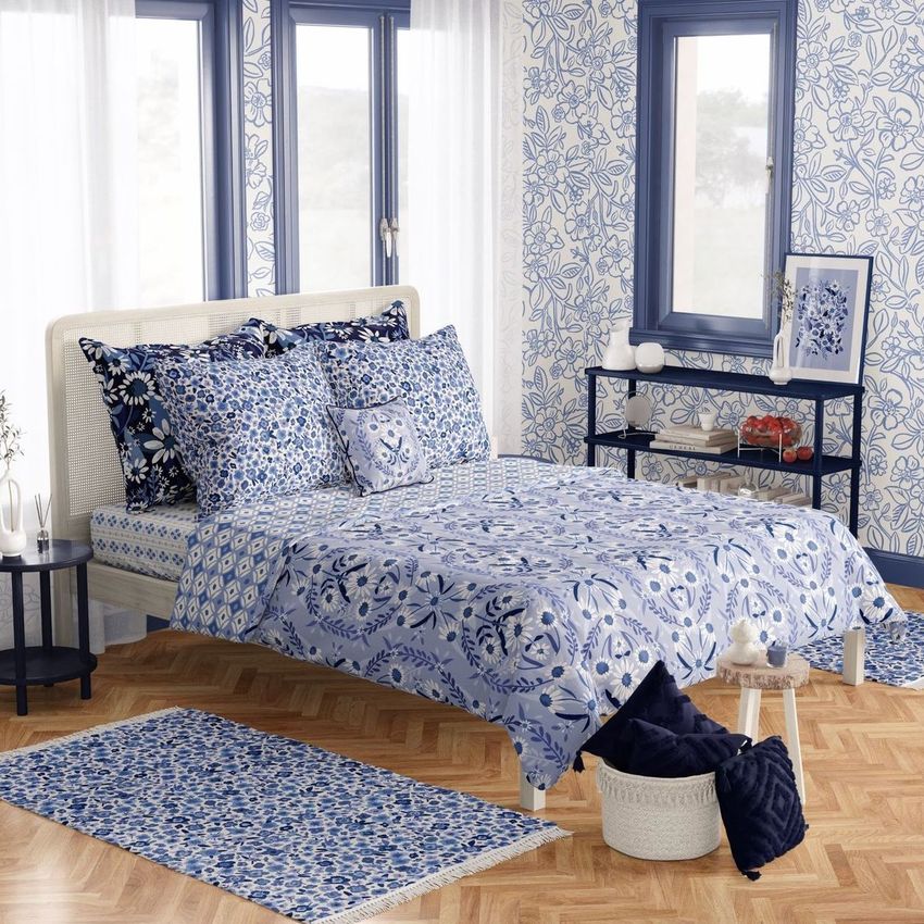 Boho bedroom bedding mockup featuring a bed with blue and white patterned linens, matching pillows, and floral wallpaper.