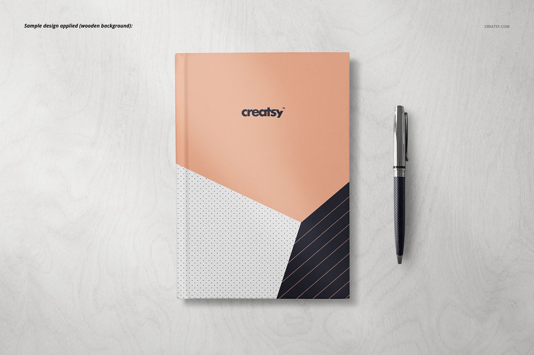 Notebook mockup featuring a geometric patterned cover in peach, white, and black, shown next to a pen on a plain background.