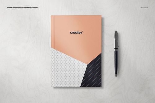 Notebook mockup featuring a geometric patterned cover in peach, white, and black, shown next to a pen on a plain background.