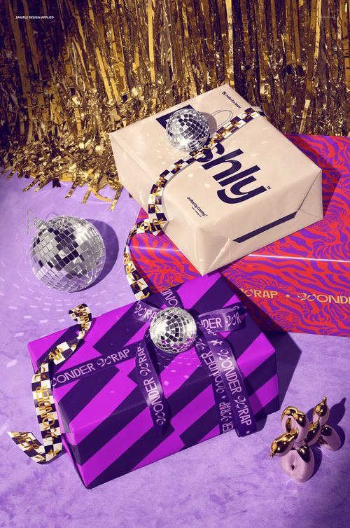 PSD mockup of gift boxes in vibrant wrapping paper and ribbon, surrounded by disco balls and gold tinsel accents.