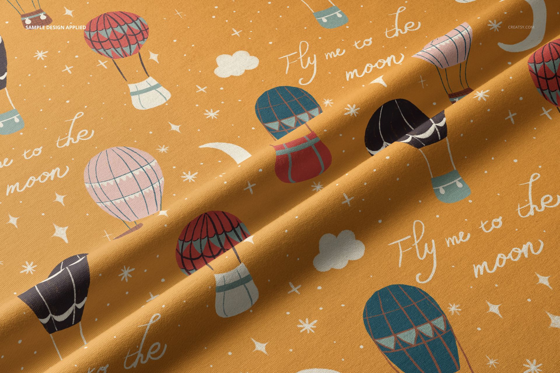 Jersey fabric mockup with soft folds, featuring hot air balloons and white handwritten text on an orange background.