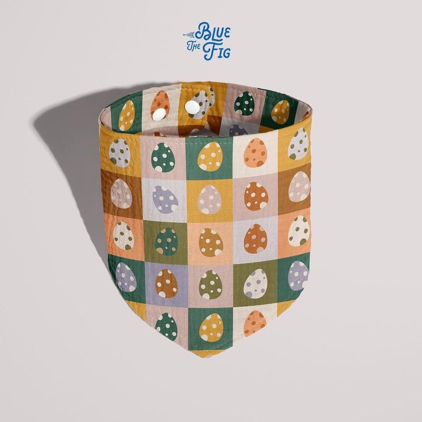 Baby muslin bandana mockup featuring a checkered pattern with colorful polka dot Easter eggs, shown on a light background.