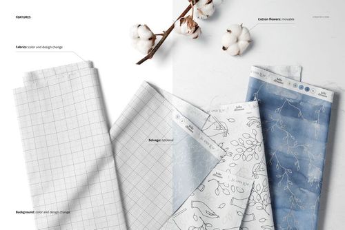 Top view of several folded fabric samples, including grid and leaf designs, arranged beside cotton flowers for a mockup scene.