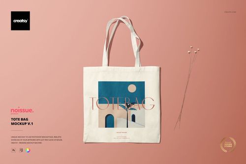 Beige tote bag mockup featuring abstract blue and cream design, shown on a pink surface with decorative stems.