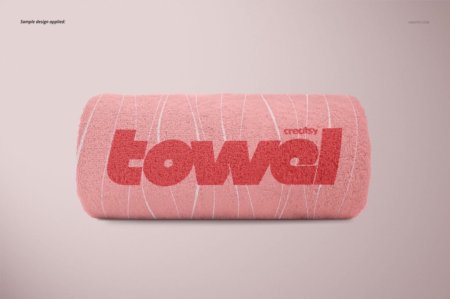 PSD mockup featuring a rolled pink towel with red text and white linear accents, positioned against a simple backdrop.