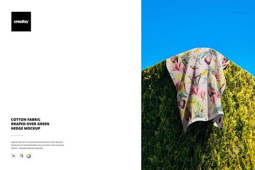 PSD mockup showing cotton fabric featuring botanical designs hanging on a vibrant green hedge with bright sky backdrop.